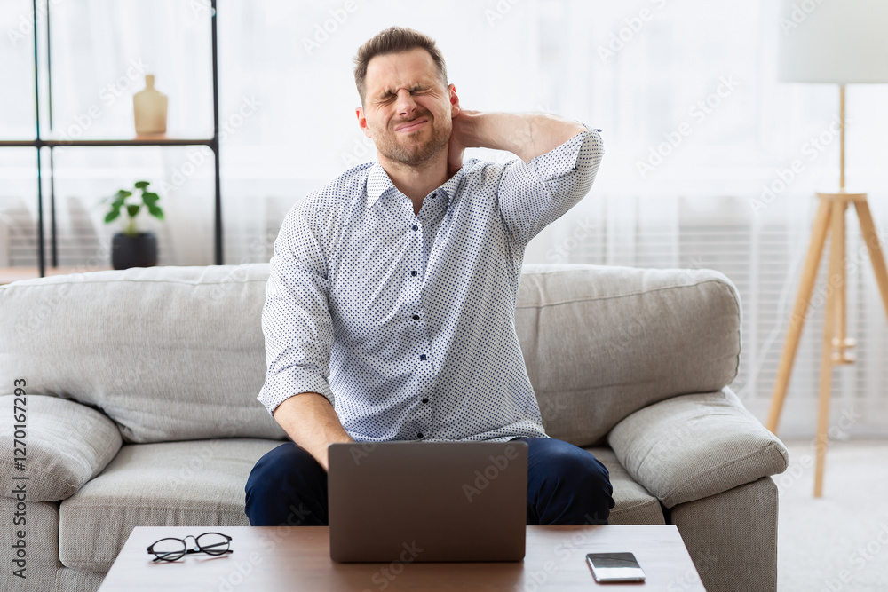 Feeling Exhaused. Businessman with neck pain after long hours at work sitting on couch, copy space Feeling Exhaused. Businessman with neck pain after long hours at work sitting on couch, copy space
