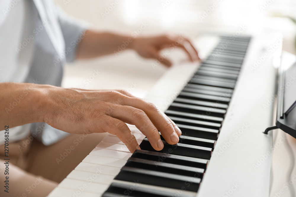 Obraz premium Man playing synthesizer indoors, closeup. Electronic musical instrument