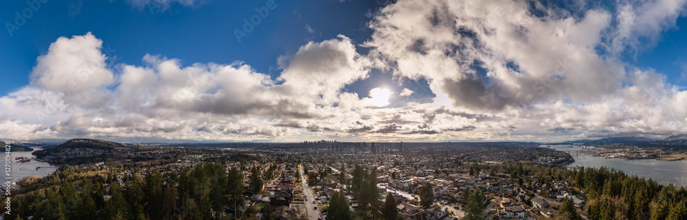 Panoramic View of a Lush Cityscape Under a Partly Cloudy Sky Panoramic View of a Lush Cityscape Under a Partly Cloudy Sky