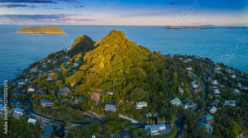 Coastal New Zealand town nestled on Mount Paku Summit lookout overlooking the ocean. Houses and roads wind through lush greenery..  Tairua, Coromandel Peninsula, New Zealand photo