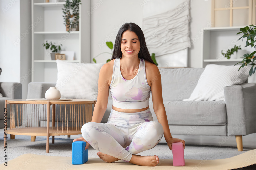 Sporty young woman doing yoga with blocks at home in morning Sporty young woman doing yoga with blocks at home in morning