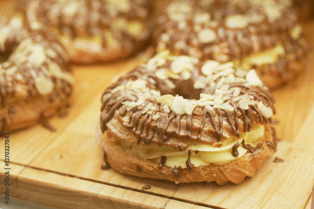 Delicious pastries topped with chocolate and almonds on wooden board Delicious pastries topped with chocolate and almonds on wooden board