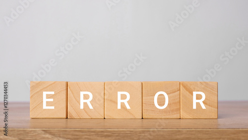 Error word written on wooden blocks on a wooden table with a light gray background. Mistake and failure concept photo