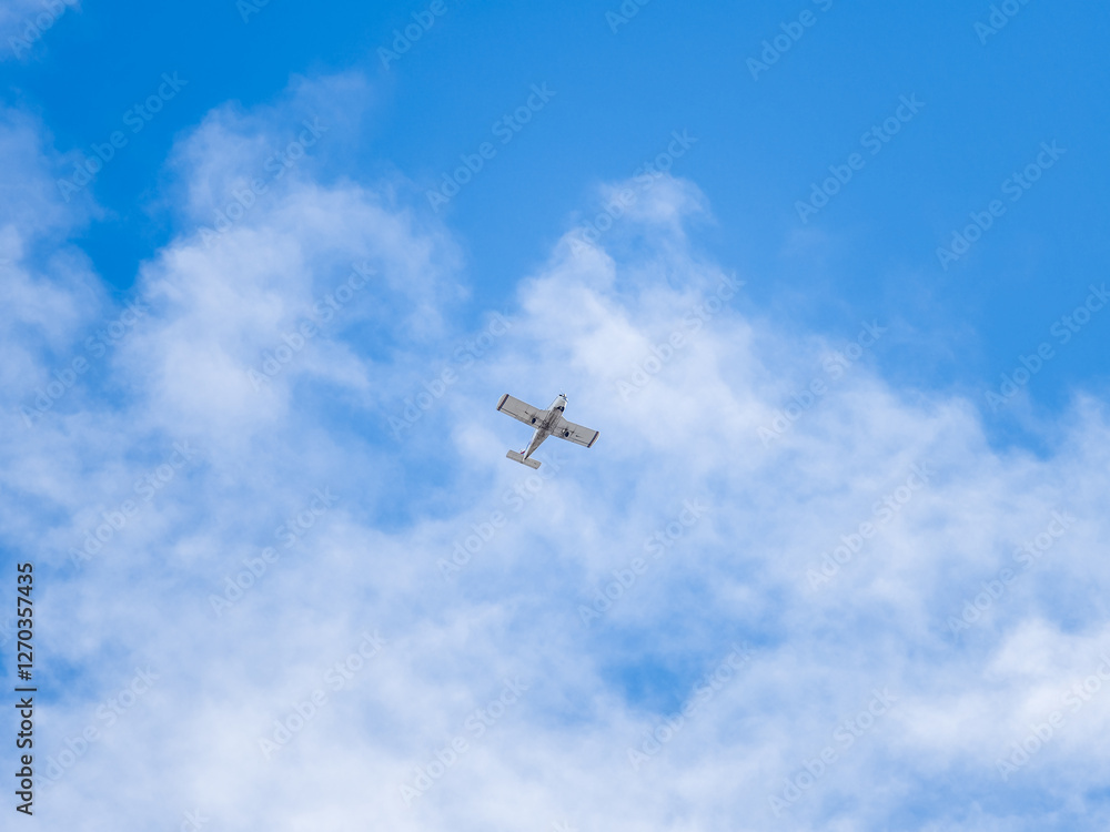 Fototapeta premium Small ultralight airplane with overhead wing and single propeller flying in sunset sky.