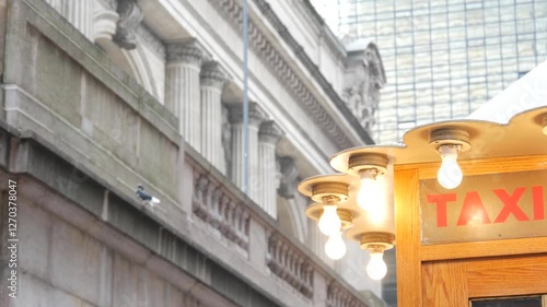 New York City, American Grand Central Terminal railway station building architecture, 42 street. Manhattan Midtown. Yellow taxi kiosk, telephone call box with bulb lights on Pershing Square, NYC, USA.
