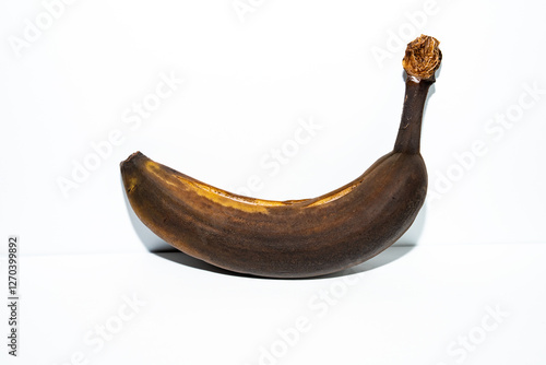 Εκτύπωση καμβά “Overripe banana with a dark, decayed texture against a white background