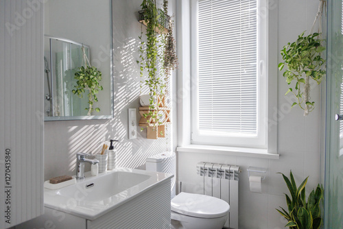 Stylish clean white bathroom with light gray tiles on the walls and lots of indoor plants.
