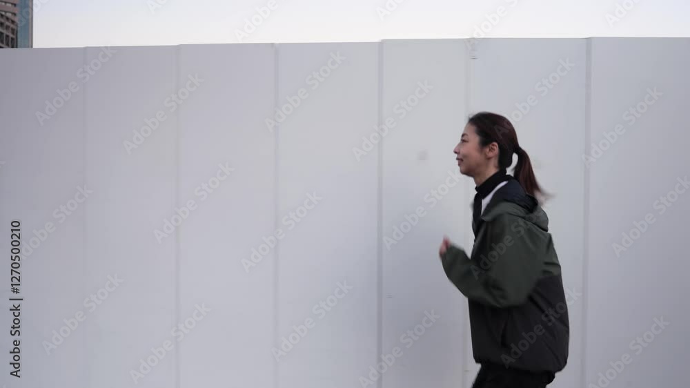 ジョギングする女性ランナーのサイドトラッキングショット ジョギングする女性ランナーのサイドトラッキングショット