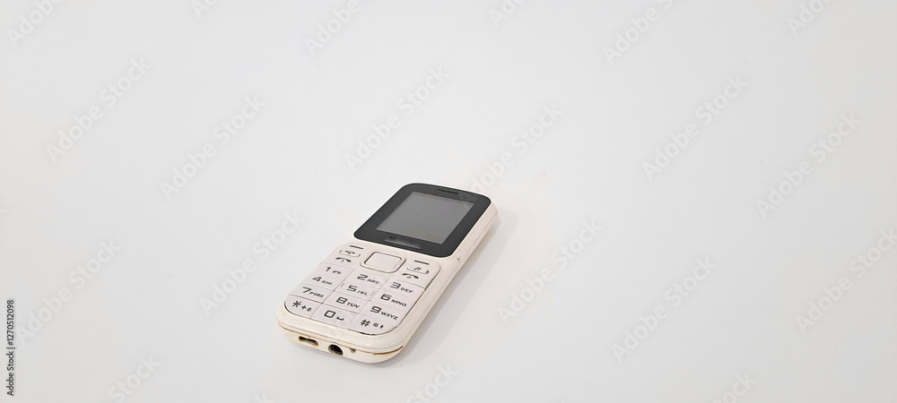White old handphone on white background. This phone has a classic design before the smart
White old handphone on white background. This phone has a classic design before the smart