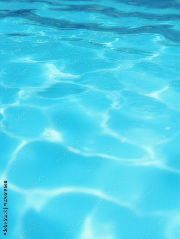 Fototapeta premium Clear blue water surface with sunlight reflections in a swimming pool