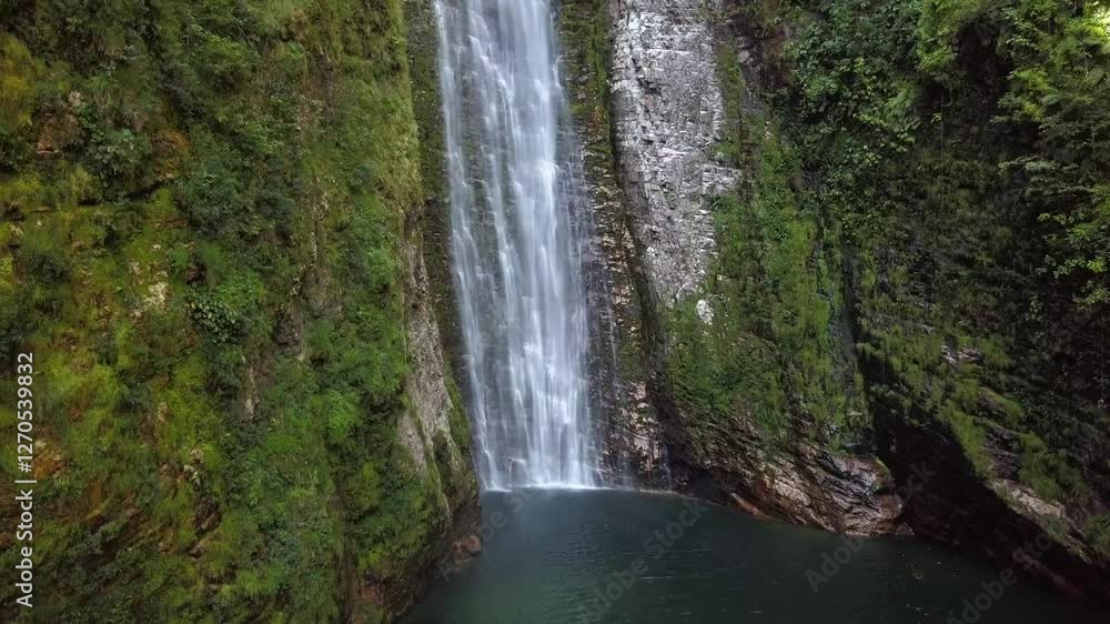 Aerial drone shot rising up, showcasing the powerful fall of the Segredo waterfall amidst the pristine landscape of Chapada dos Veadeiros, Brazil Aerial drone shot rising up, showcasing the powerful fall of the Segredo waterfall amidst the pristine landscape of Chapada dos Veadeiros, Brazil