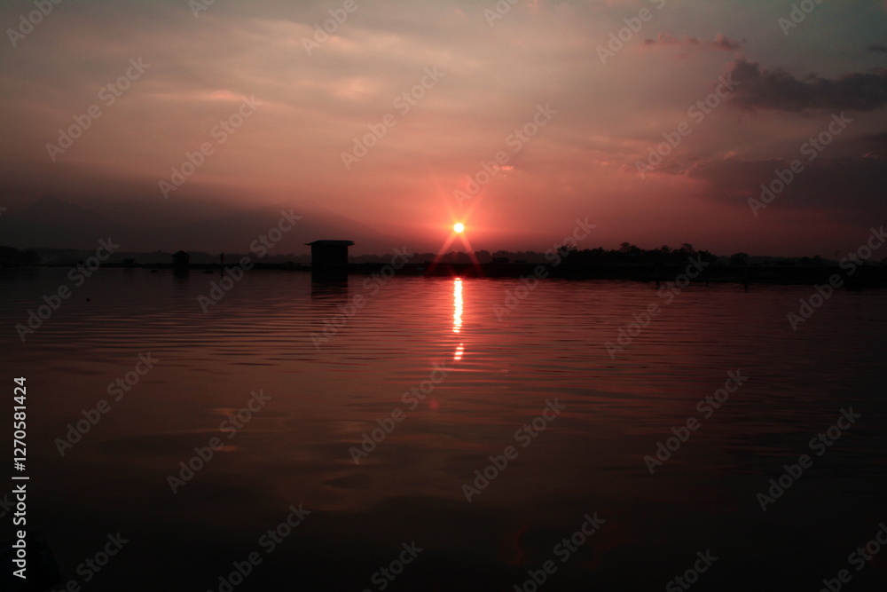 Naklejka premium the atmosphere of the fish pond in the reservoir at sunset