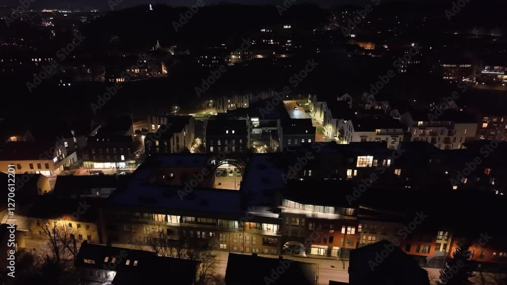 Illuminated modern residential neighborhood in Vilnius, Lithuania, captured at night with surrounding city lights. Illuminated modern residential neighborhood in Vilnius, Lithuania, captured at night with surrounding city lights.