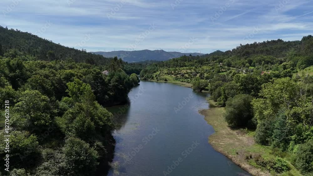 Aerial view of the Ave River flowing through lush green hills in Vieira do Minho, Portugal Aerial view of the Ave River flowing through lush green hills in Vieira do Minho, Portugal