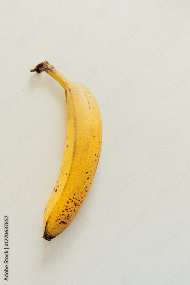 single banana against white minimalist background single banana against white minimalist background