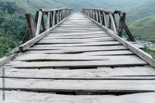 Weakness and damaged concept. Old wooden bridge crossing a scenic valley in misty surroundings.