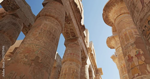 Up view between the engraved stone pillars of Luxor temple in Egypt
