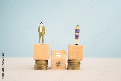 Gender pay equality concept. Man and woman icon  on wooden cube block and hand flipped unequal to equal sign with blurred stack of coins