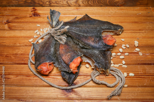 Dried flounder with caviar lies tied in a bundle on a wooden table photo