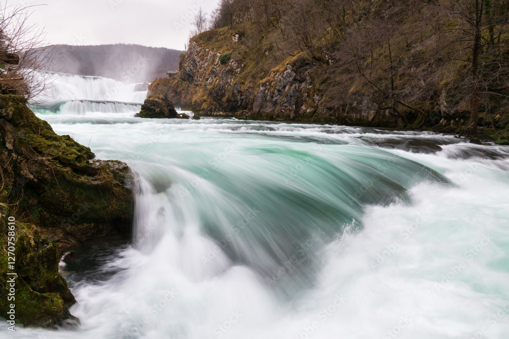 Waterfall and cascade on Una river, water sprays and flows in motion blur, turquoise colour Waterfall and cascade on Una river, water sprays and flows in motion blur, turquoise colour