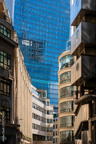 Modern skyscrapers in The City, London, reflecting financial power and urban design. Architectural contrast between glass towers and historic buildings.