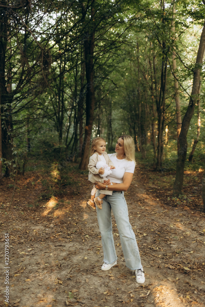 Fototapeta premium Mother Holding Child During Stroll in Peaceful Green Forest