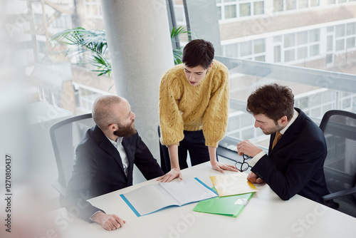 Colleagues discussing business strategy in a modern office boardroom photo