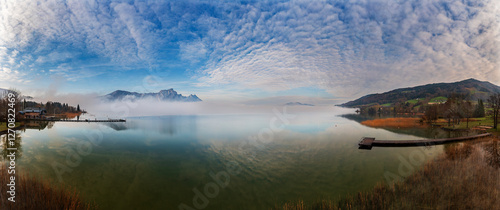 Drone view of morning mist over Mondsee with Drachenwand in Salzkammergut, Austria photo