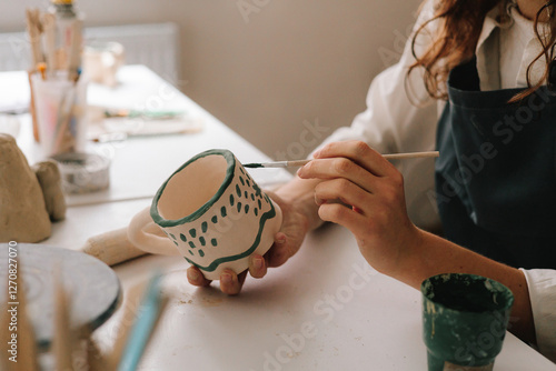 Cuadro en lienzo Experienced artist painting designs on ceramic cup in pottery workshop