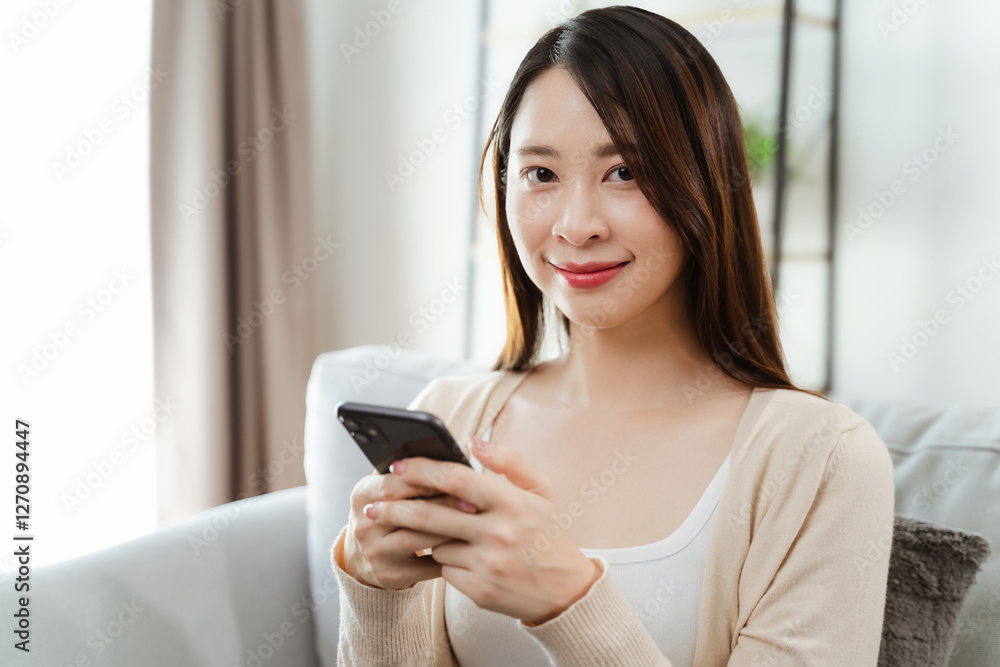 Beautiful young woman holding and using a smartphone, using social media, shopping online Beautiful young woman holding and using a smartphone, using social media, shopping online