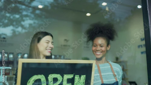 Two woman owner hold open sign at refill shop.