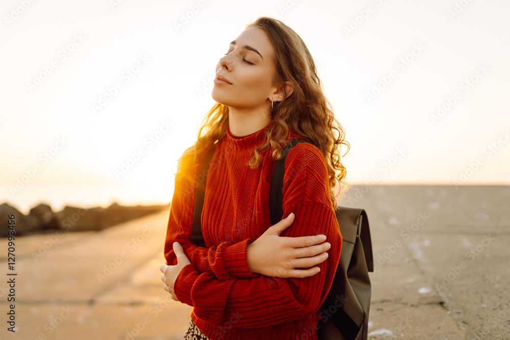 Female tourist admires nature at the beach near a vibrant red lighthouse. Travel concept Female tourist admires nature at the beach near a vibrant red lighthouse. Travel concept