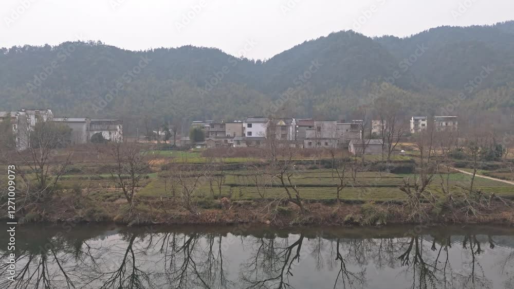 The landscape of villages along the river in the south of the river and the reflection of trees along the river The landscape of villages along the river in the south of the river and the reflection of trees along the river