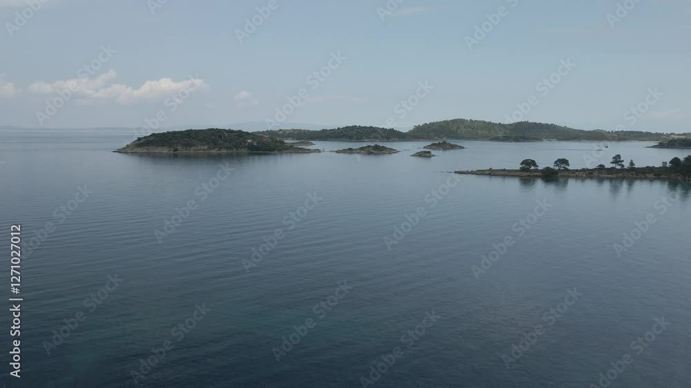 Day flying above small island strips with green vegetation and rocky coastline in the Mediterranean at Chalkidiki peninsula, Greece. Day flying above small island strips with green vegetation and rocky coastline in the Mediterranean at Chalkidiki peninsula, Greece.