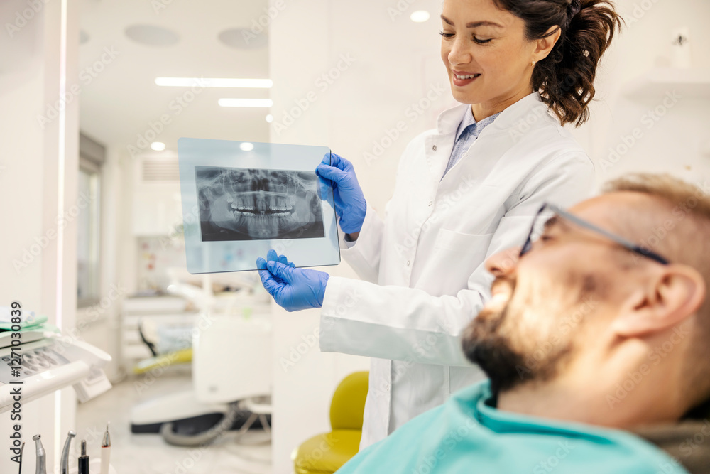 Smiling dentist holding an x-ray of teeth at dentist office and showing it to a patient. Smiling dentist holding an x-ray of teeth at dentist office and showing it to a patient.