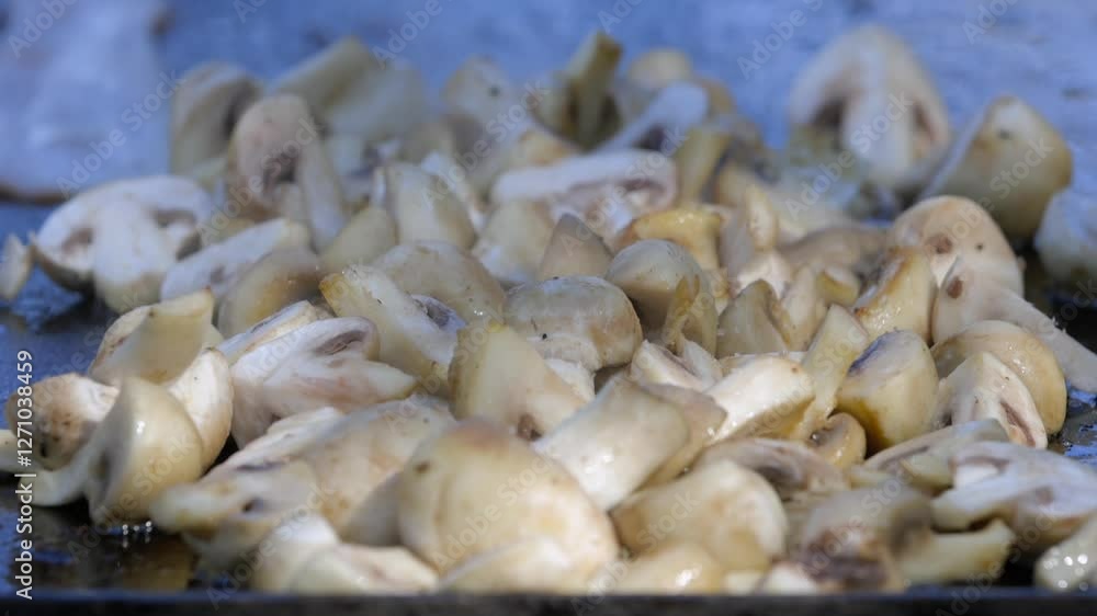 Pile of chopped button mushrooms grill outdoors on large griddle Pile of chopped button mushrooms grill outdoors on large griddle