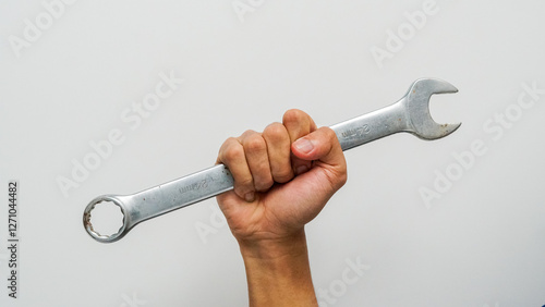 Mans hand holds a spanner measuring 24mm isolated on white background