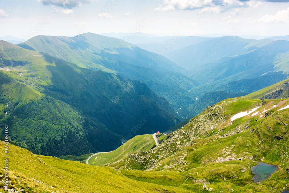 mountain landscape of romania in summer. vacation season. beautiful outdoor scenery with alpine lake. scenic view in to the valley. travel background with blue sky and clouds. grassy slope