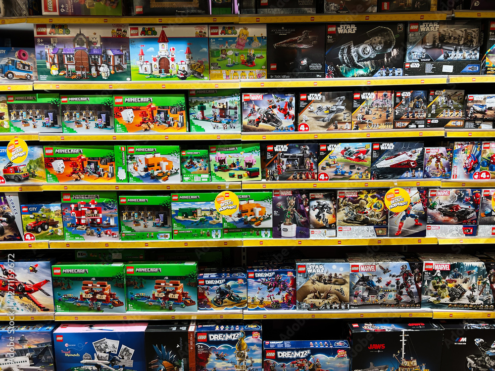 Naklejka premium Lviv, Ukraine - February 16, 2025: Colorful shelf display featuring LEGO themed sets from various series and franchises