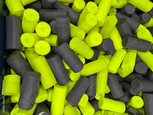 Foam cylinder jumping pit background. Funny kids playing zone with soft covered blocks.