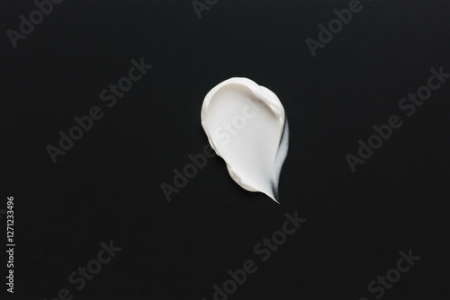 White cream smear on a dark background, showcasing a minimalist and elegant skincare concept for beauty and wellness products