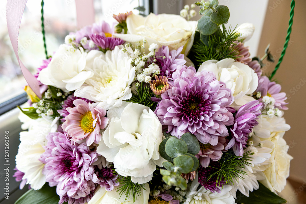 Close-up of a basket of flowers by the window.