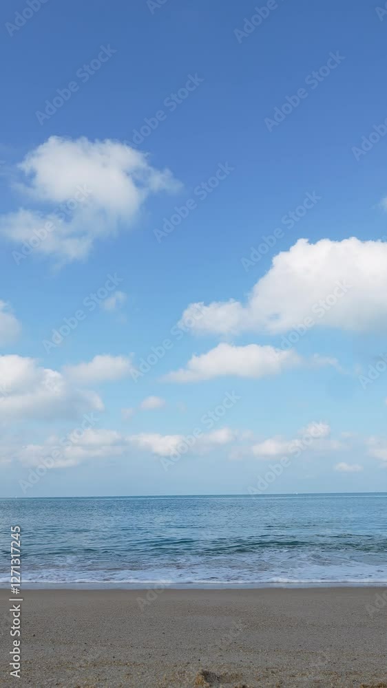 Beautiful vertical landscape beach sea in good weather day. Sand blue seawater blue sky background Nature and travel concept Beautiful vertical landscape beach sea in good weather day. Sand blue seawater blue sky background Nature and travel concept