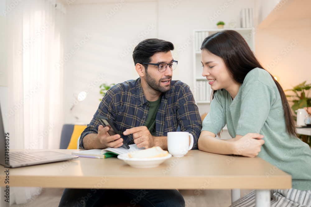 Portrait of a young freelancer smiling while working online via laptop at home with his girlfriend Portrait of a young freelancer smiling while working online via laptop at home with his girlfriend