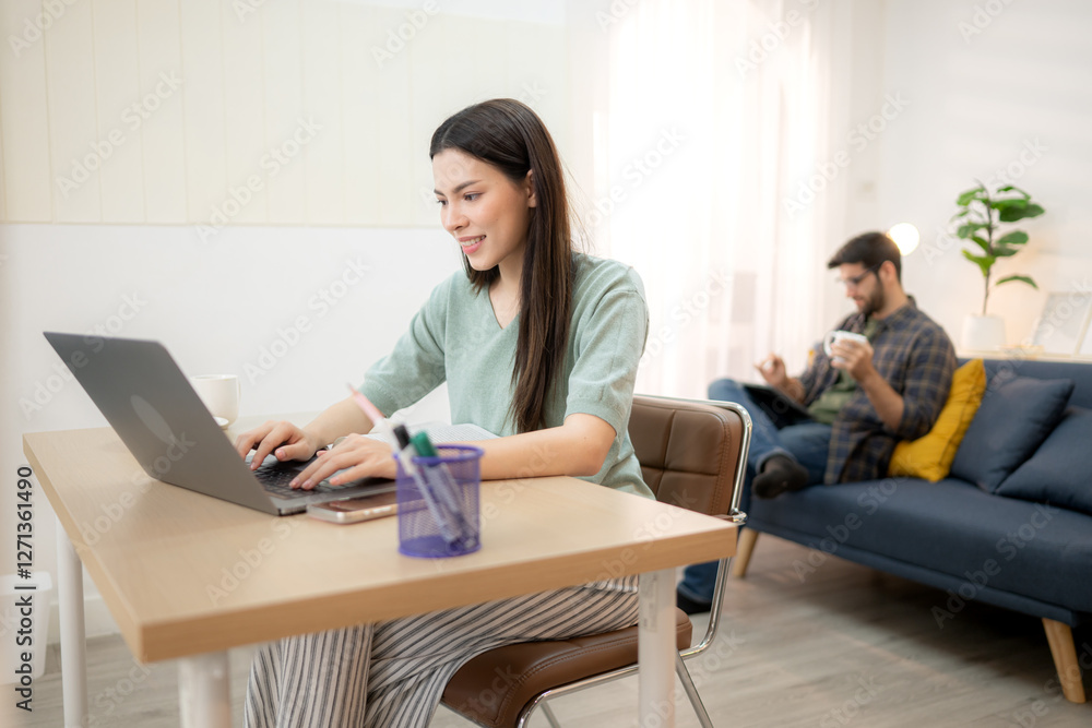 Portrait of a young freelancer smiling while working online via laptop at home with his boyfriend Portrait of a young freelancer smiling while working online via laptop at home with his boyfriend