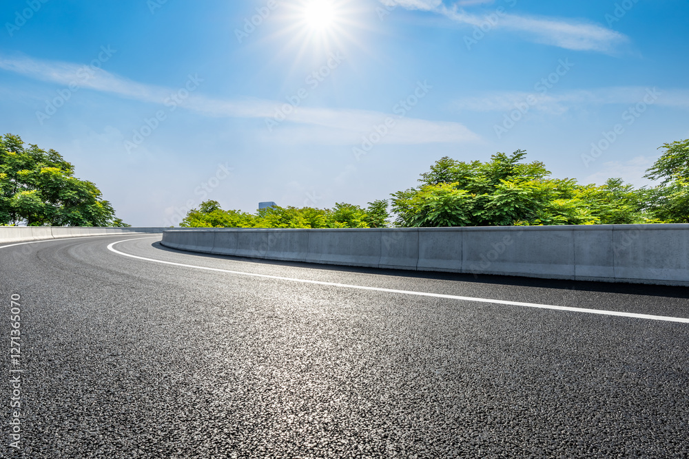 A curving road under the bright sun and blue sky
