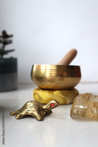 Nepal singing bowl, metal turtle as a sign of wisdom and citrine crystal on the table. 