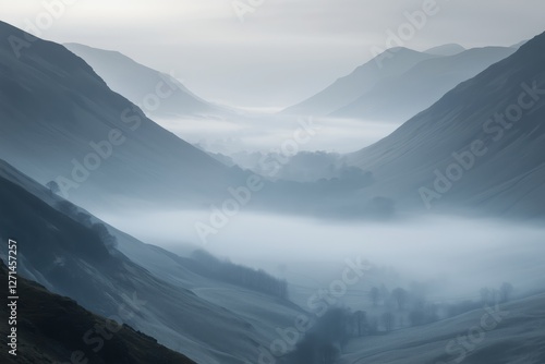Misty mountain landscape at dawn with layers of blue hills and valleys
