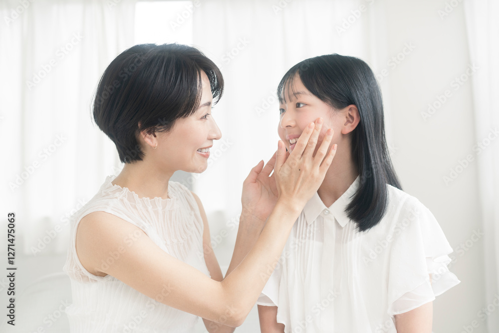 母娘のビューティーイメージ/娘が母親の頬を触っている。 母娘のビューティーイメージ/娘が母親の頬を触っている。