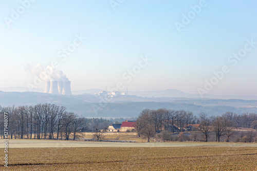 Obraz na płótnie A farmhouse in southern Czechia and the Temelin Nuclear Power Plant on the horizon. Cold winter morning. w salonie